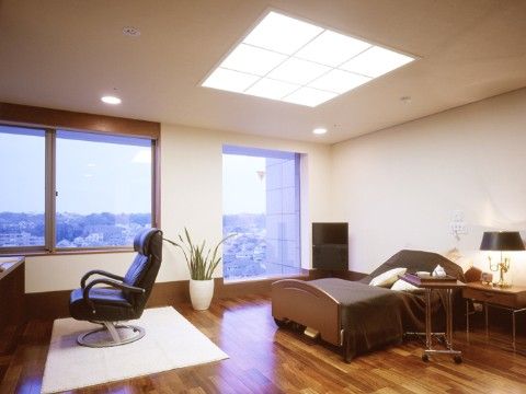 大きな窓がある高層階の居室からは街を一望できる。電動リクライニングのベッドを採用し、快適な生活をサポートする。