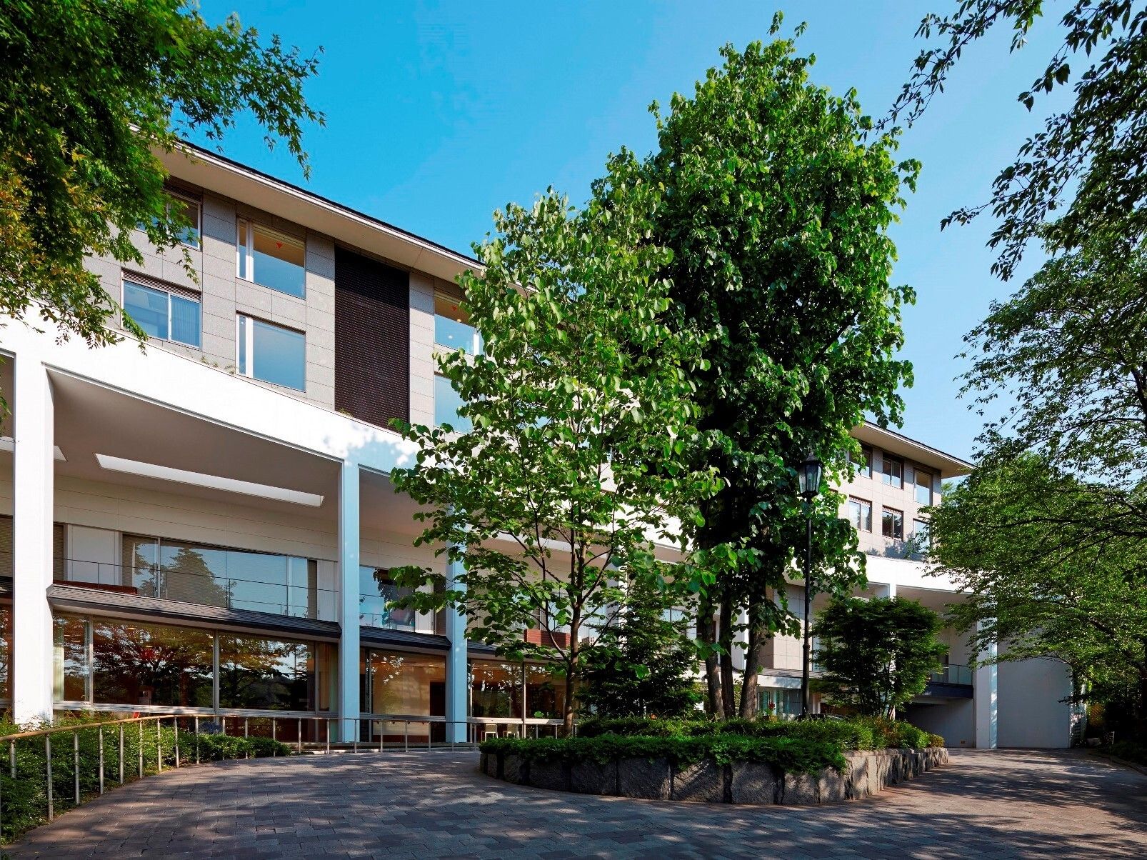 植え込みを設けロータリーある車寄せを完備した施設玄関前