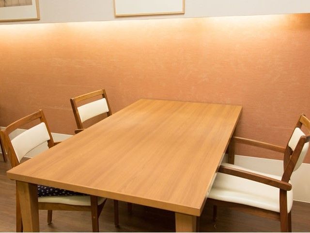 木製の手^ブルと椅子が置いてある小さな部屋の様子。会議室内の写真