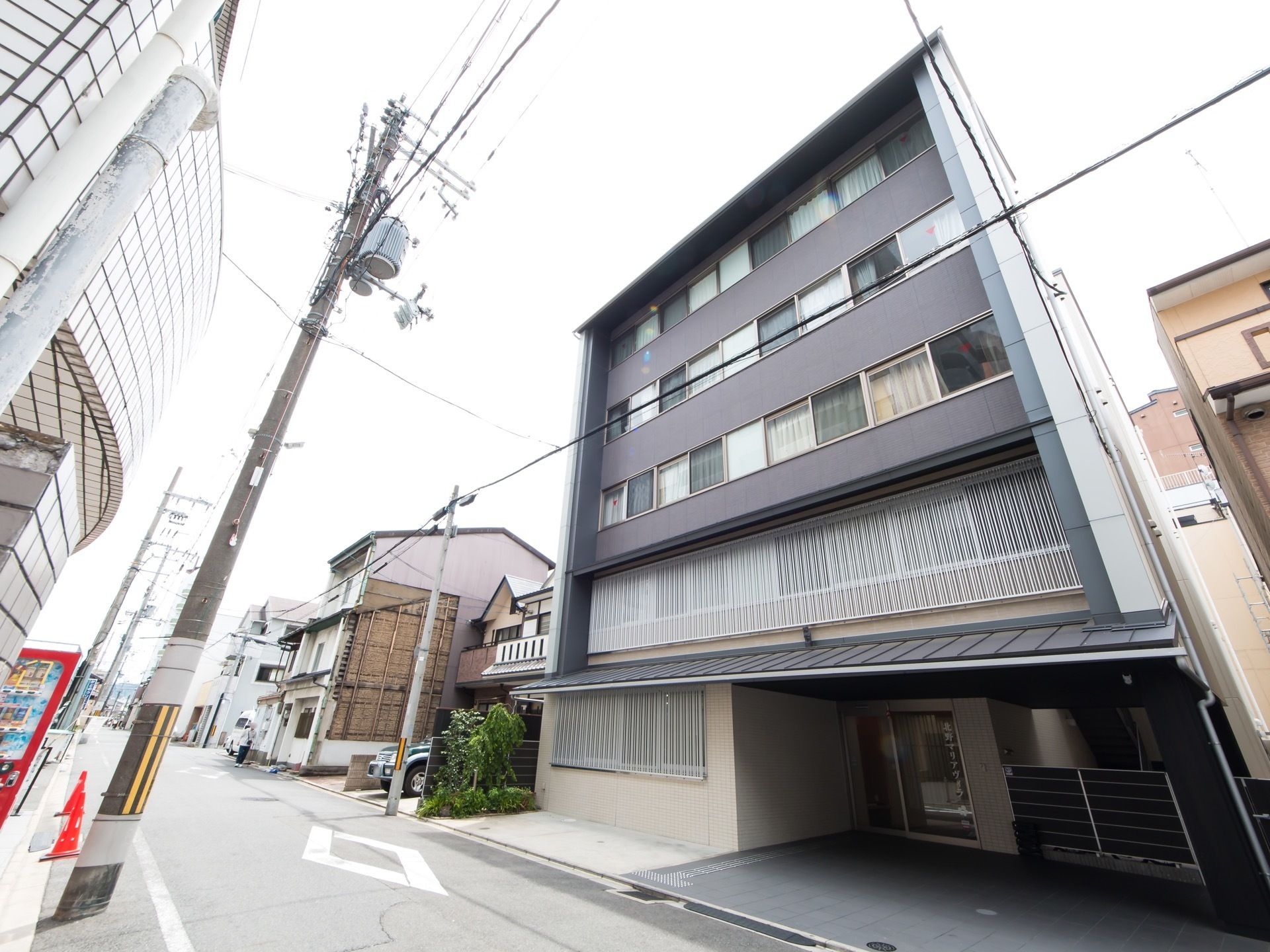 ビジネスホテルを思わせるような５階建てのモダンな建物である。周辺は、主要道路に面した閑静な住宅街である。