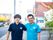 スタッフが肩を組んでこちらを向いて微笑んでいる様子。後ろに街並みが写っている