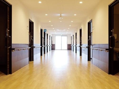 まっすぐな廊下は幅が広く、突き当りに窓があり、両サイドに手すりが付いている。