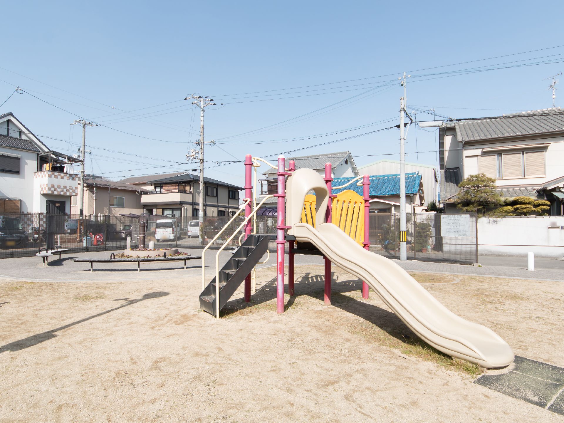 住宅街の中にある日当たりの良い公園である。中央に滑り台が配置されており、奥にはベンチや花壇が設けられている。