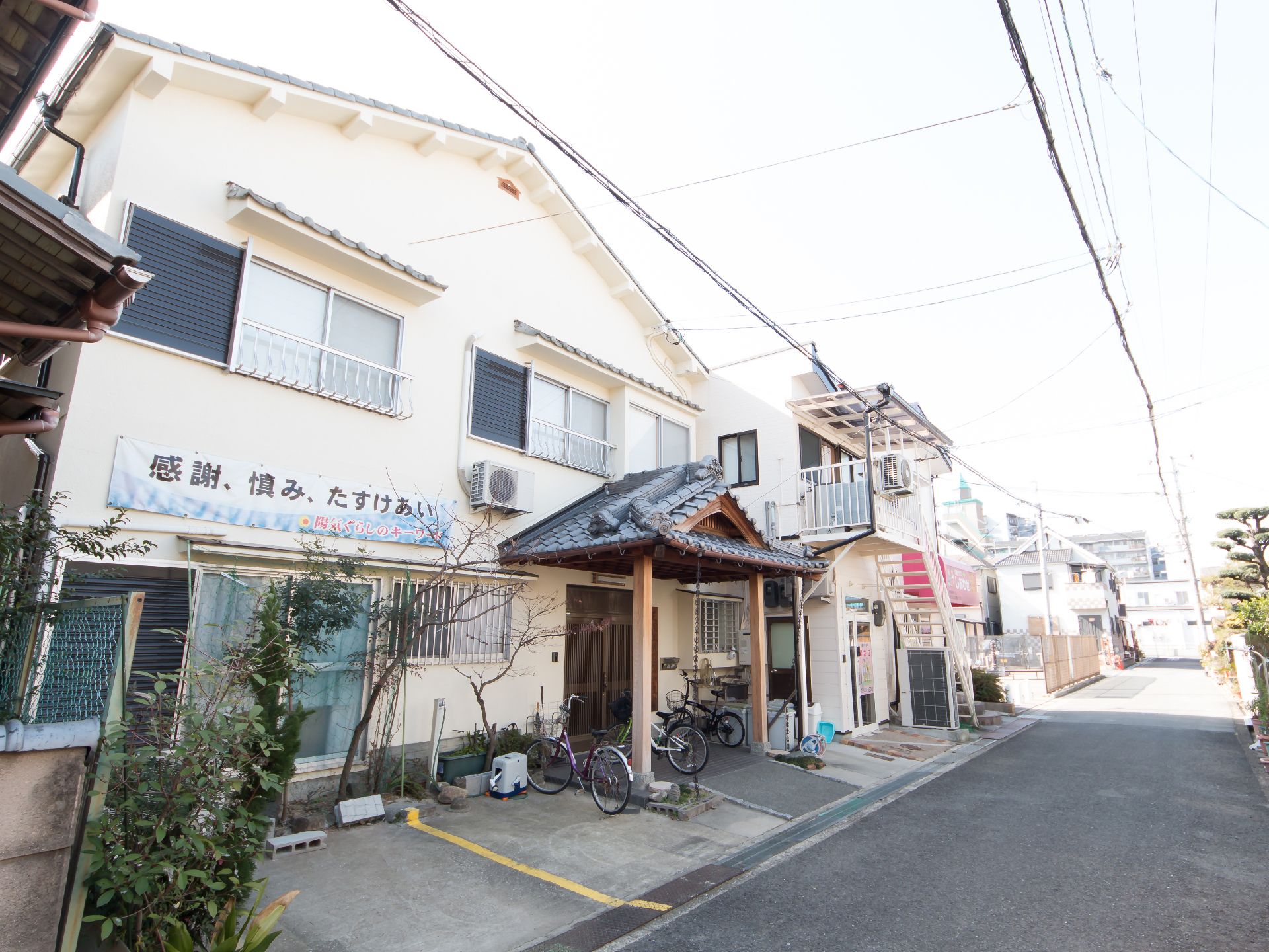 住宅街の中に建てられたグループホームで、周辺には高い建物がない。目の前は車通りの少ない道路となっている。