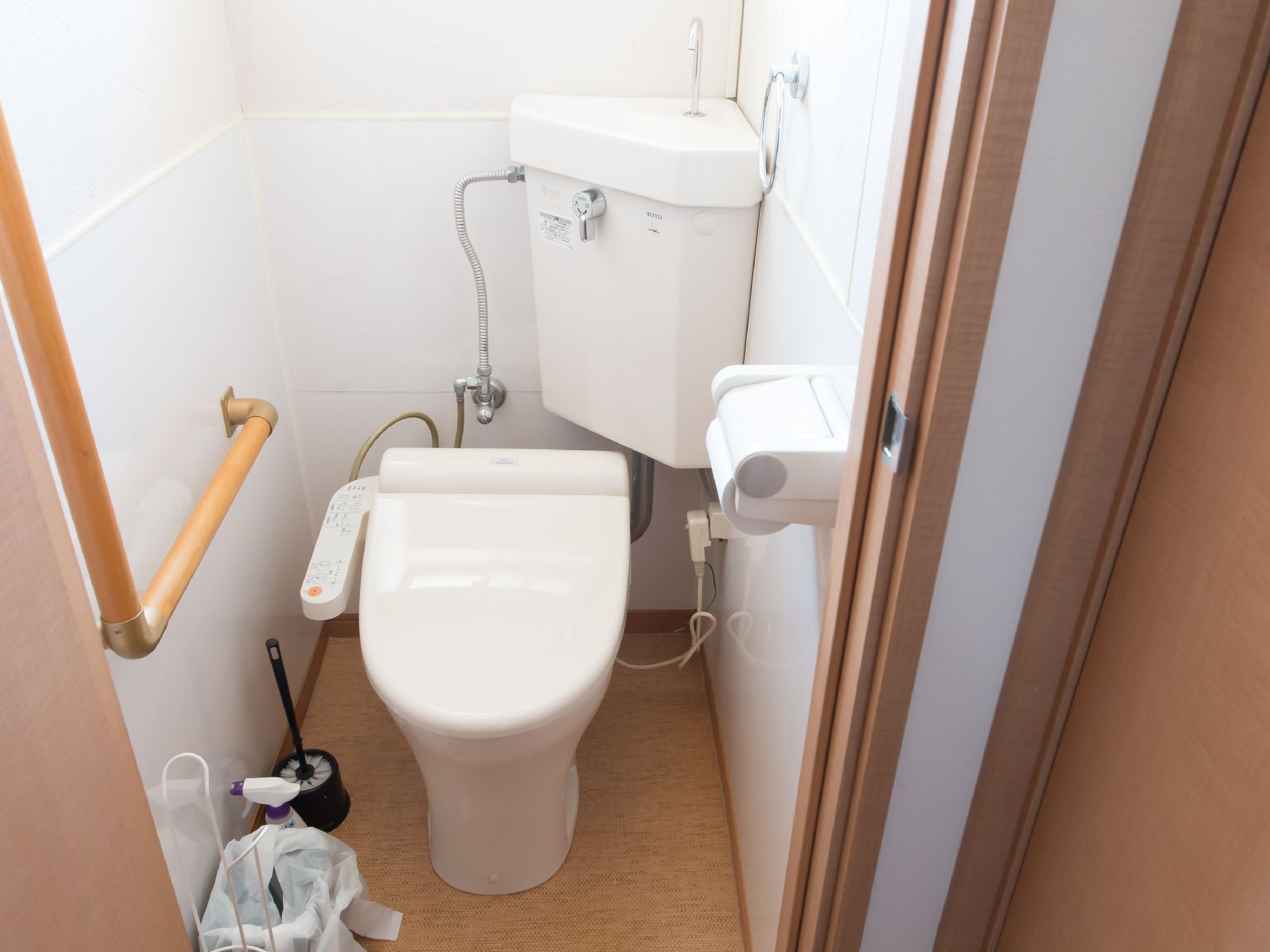 手すり付きの広めのトイレ。高齢者用の装置付きトイレの様子