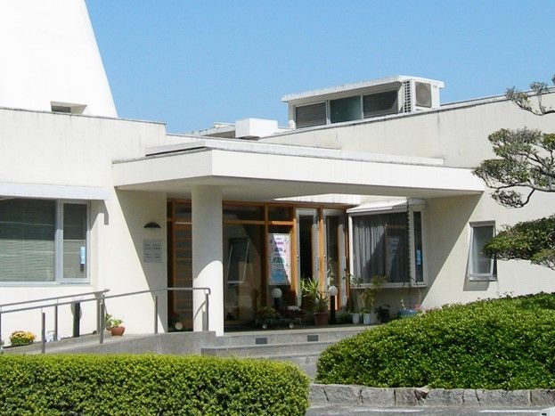 エントランス部分に雨除けとスロープが付いている建物の様子。白を基調にした清潔感のある建物