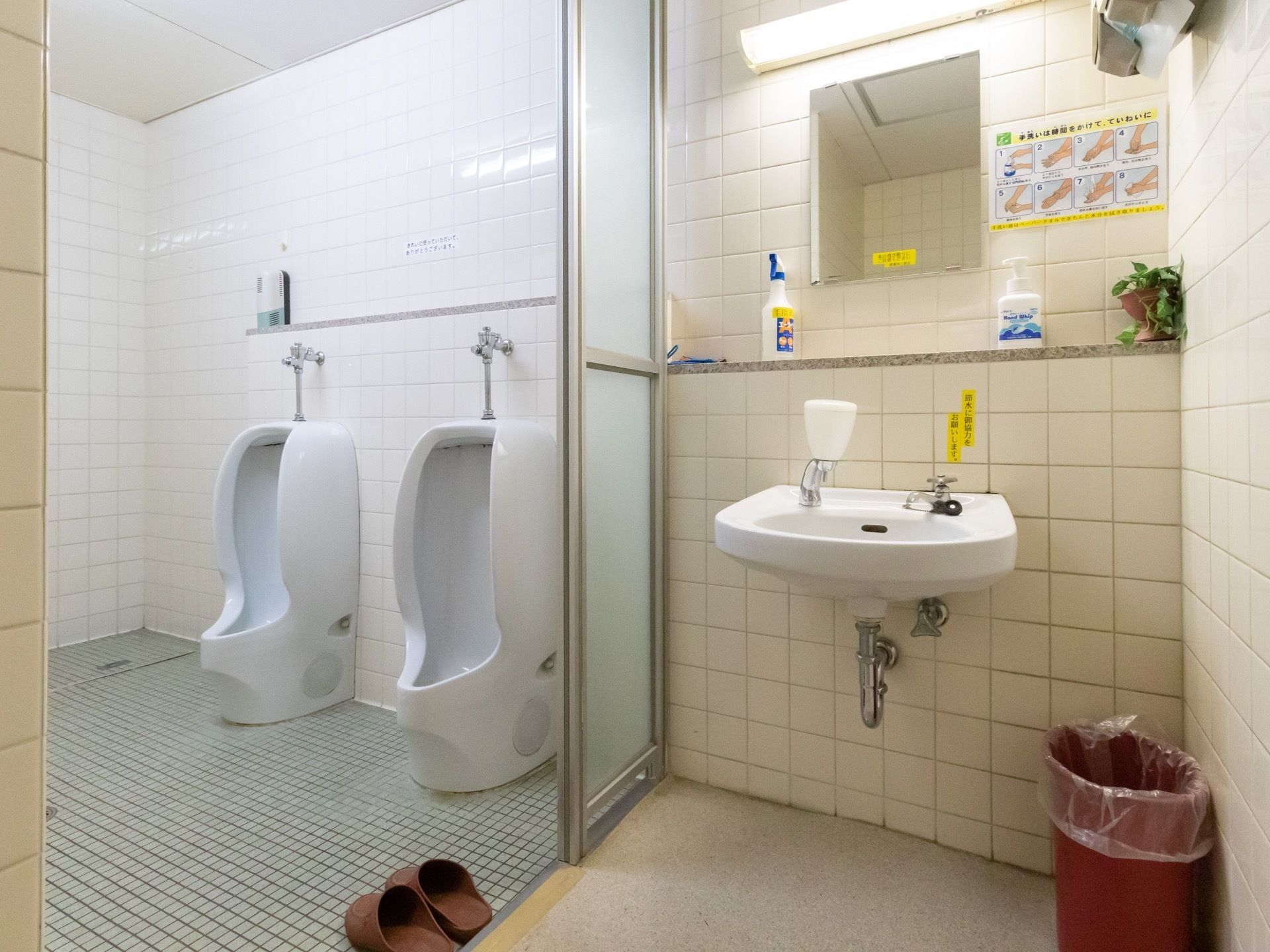 男性用小便器が二つ並んでいる、共同トイレである。ガラスで仕切られた隣には手洗い場があり、鏡や石鹸、ペーパータオルが備わっている。
