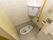 共同トイレに和式便器が設置されている。利用時に正面に位置する壁には、まっすぐな手すりが備わっている。