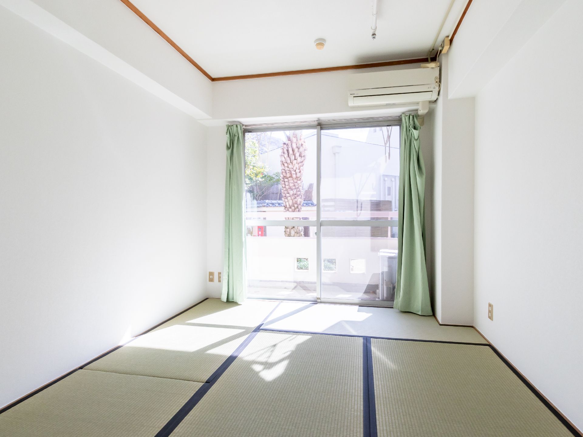 ベランダに出られる大きな窓がある、畳が敷かれた部屋