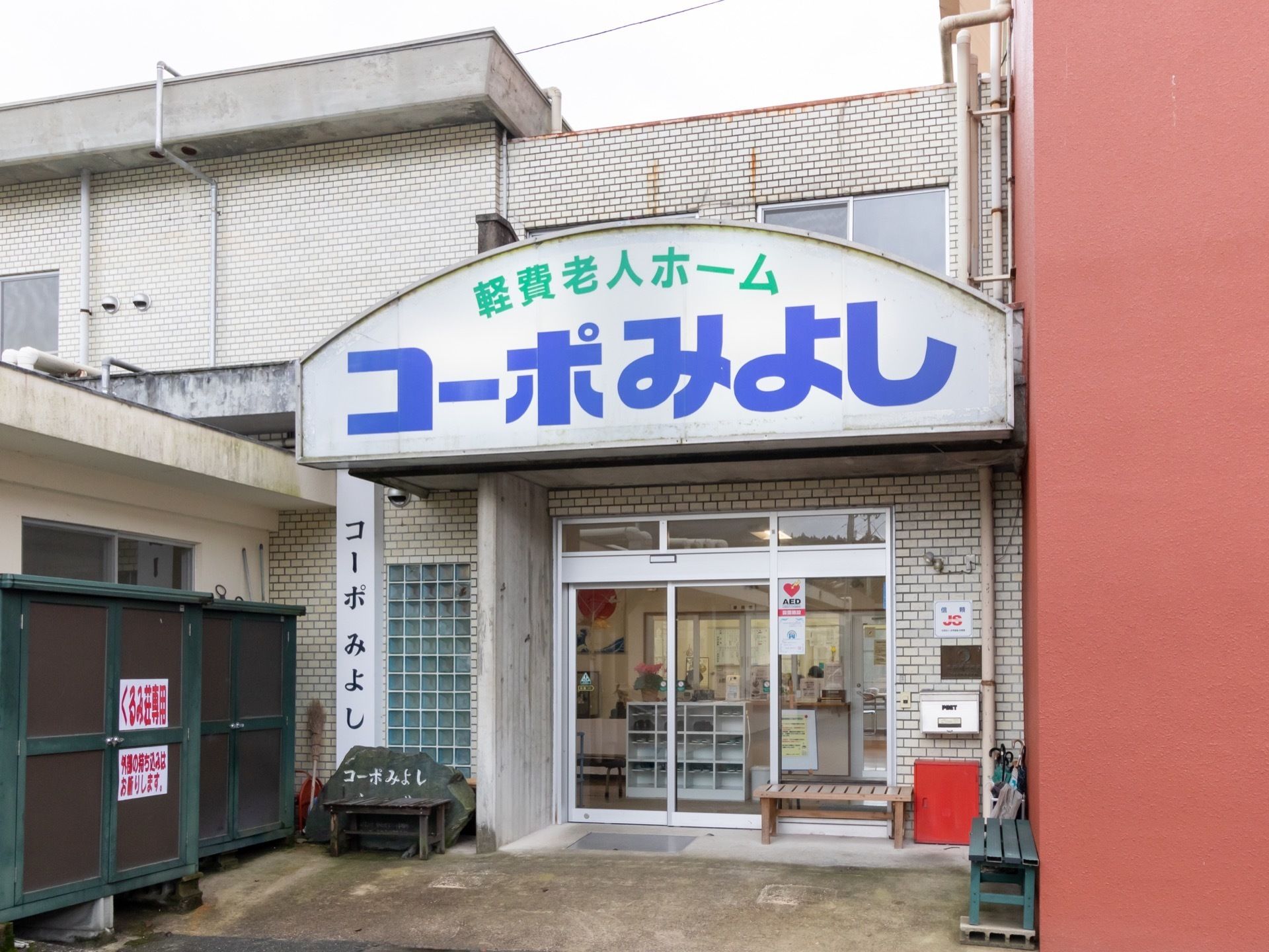 玄関ポーチ上には、大きく施設名が掲げられている。正面玄関は自動ドアである。玄関先にはベンチが複数置かれている。