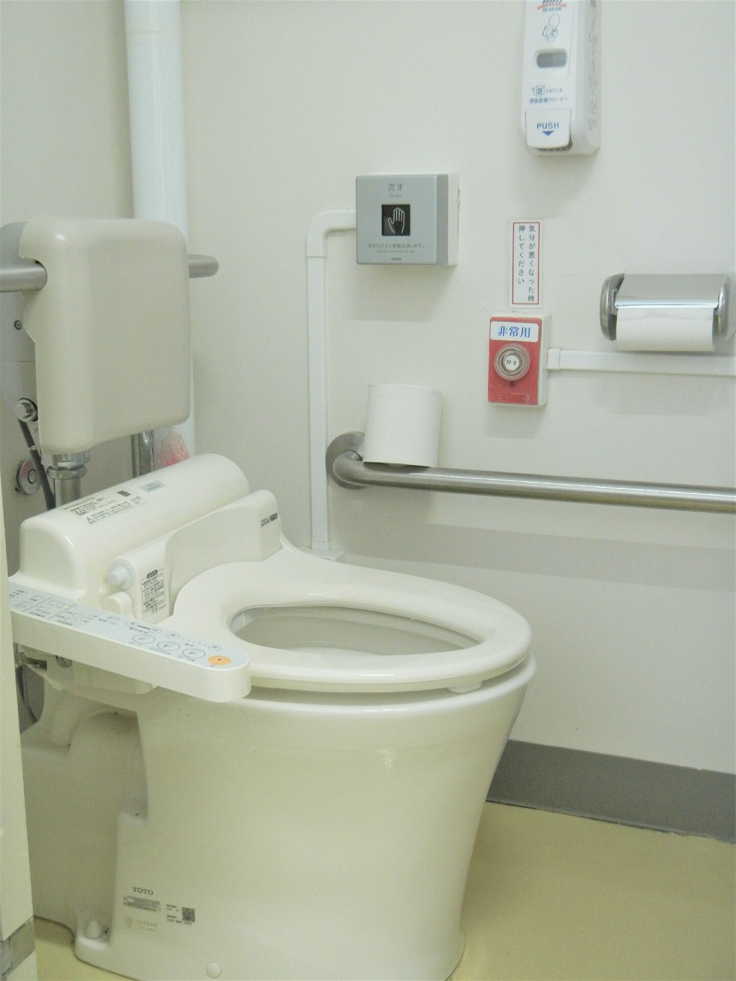 背もたれの板や温水洗浄便座が取り付けられているトイレ