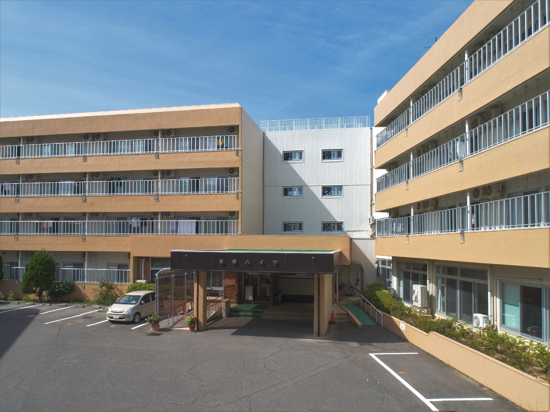 アクリル板がベランダに嵌められた居室が並んでいる施設外観