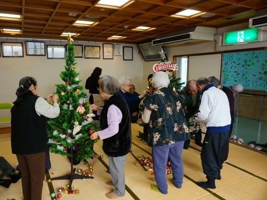 クリスマスの飾りつけをしている高齢者の様子。施設内の飾りつけ