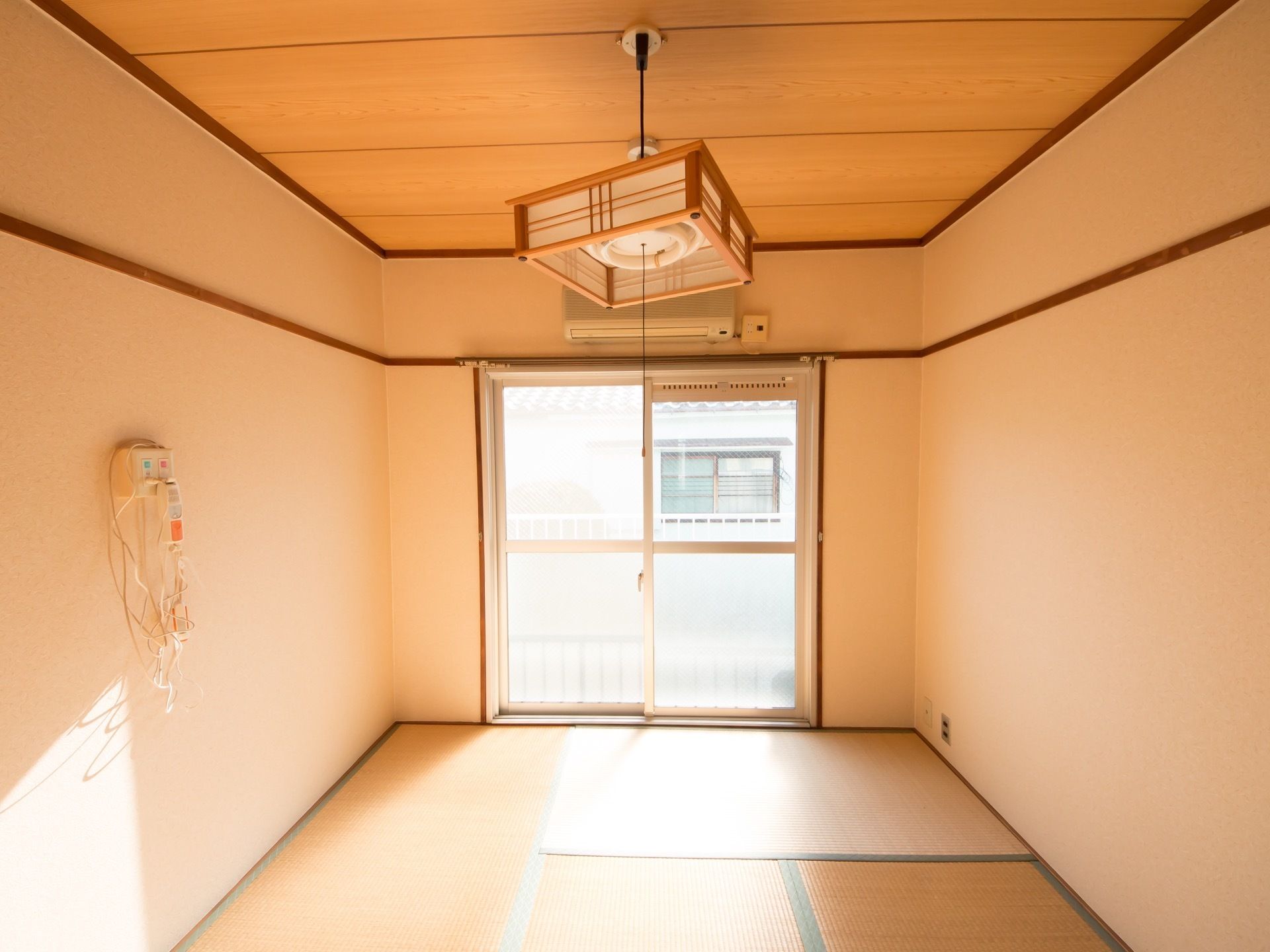 畳が敷かれた和室になっており、窓から光が差し込み明るい。壁にはナースコールがついていて、窓の上にはエアコンが設置されている。