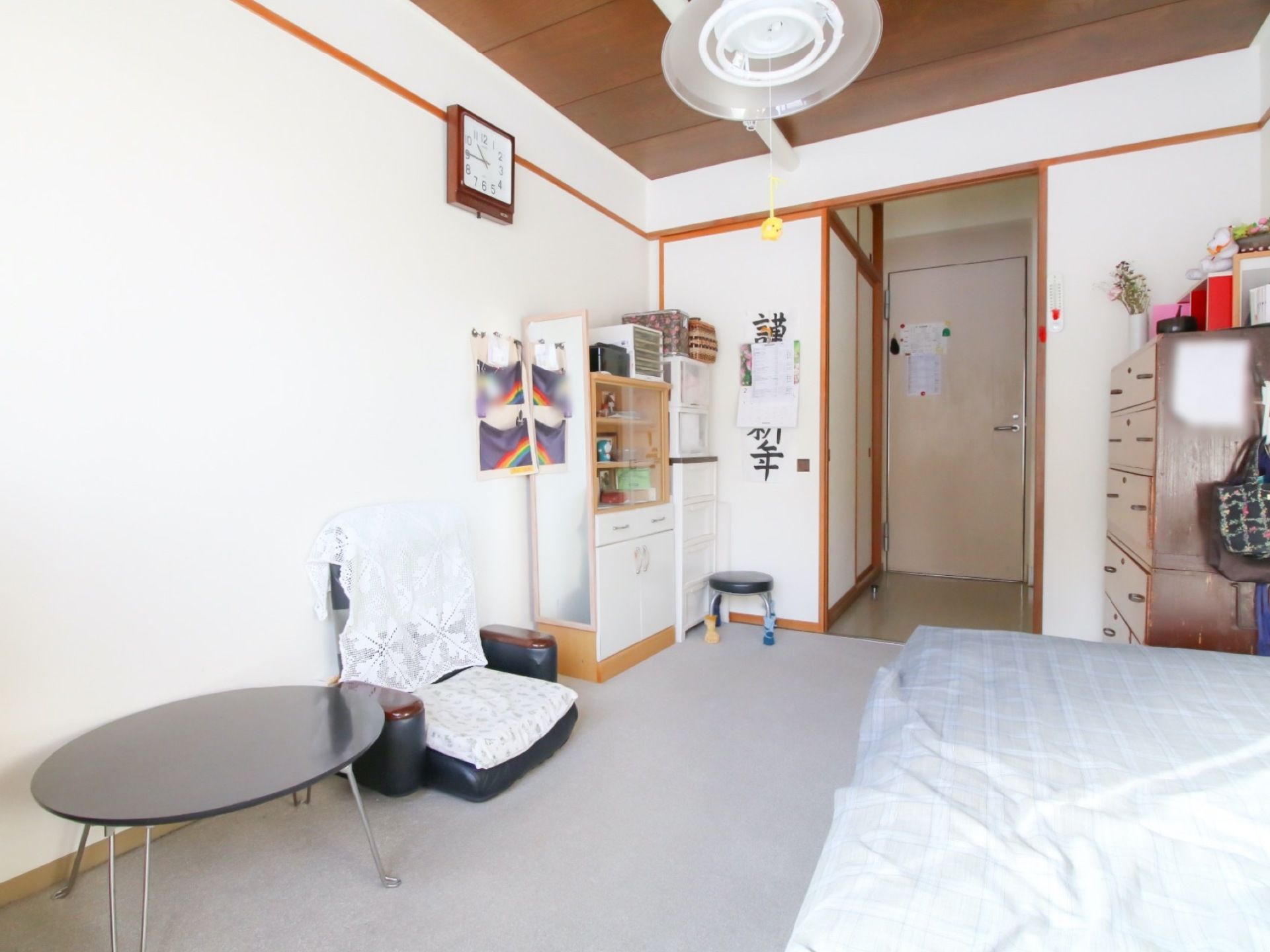 居室のドアの手前に押し入れが備わっている。室内にタンスや衣装ケース、座卓や座椅子、ベッドが置かれている。