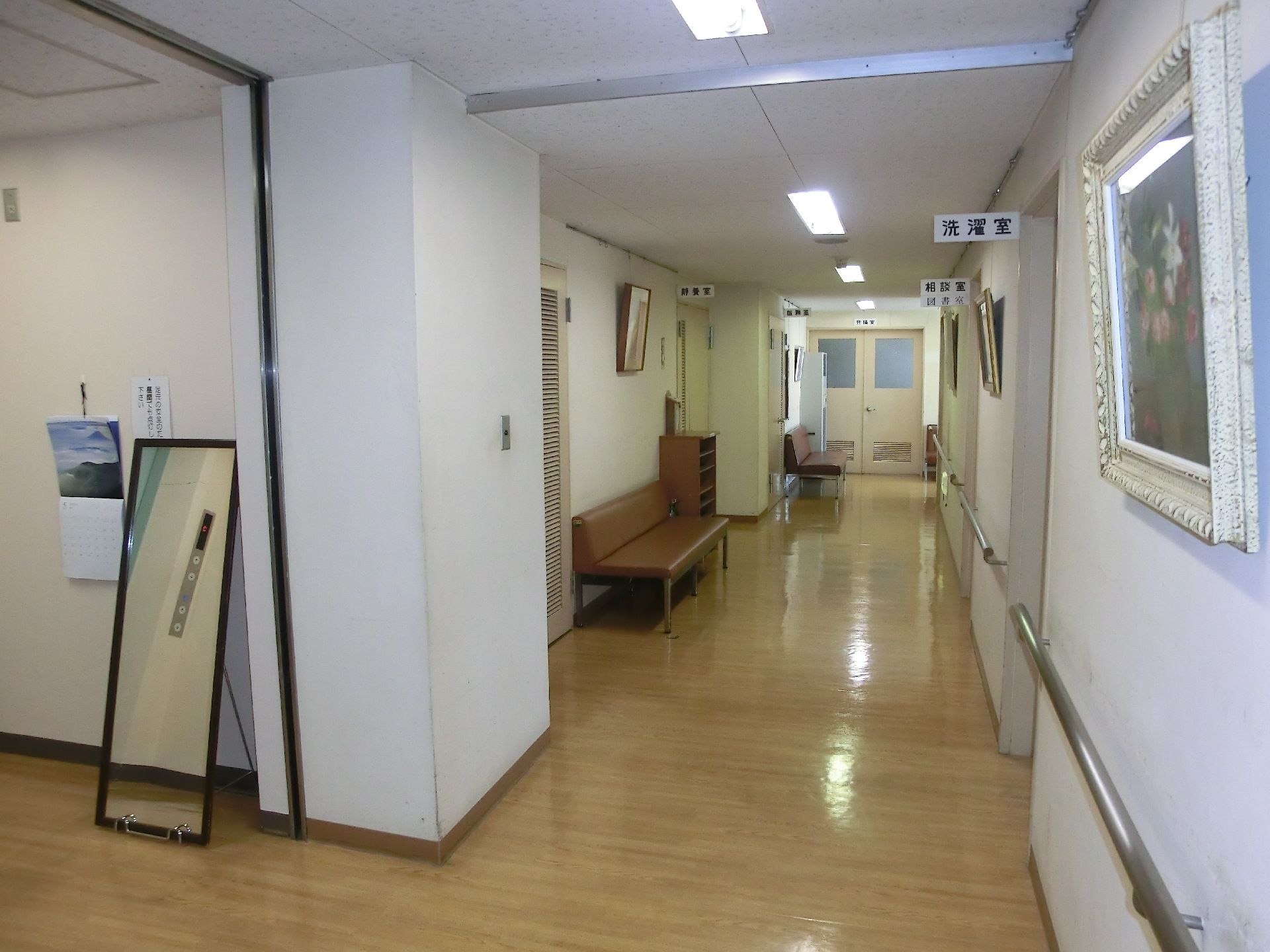 「洗濯室」と書かれた部屋が手前に貼り、廊下には手すりが設置され、絵画や鏡が飾られている。