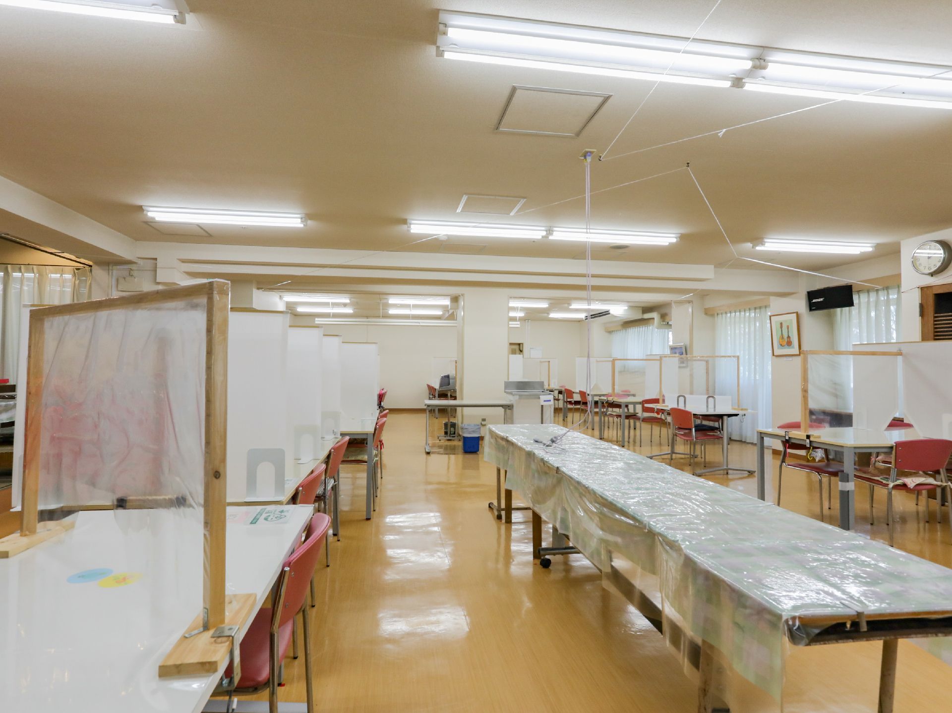 椅子と仕切り板がついているテーブルが設置された共有スペース