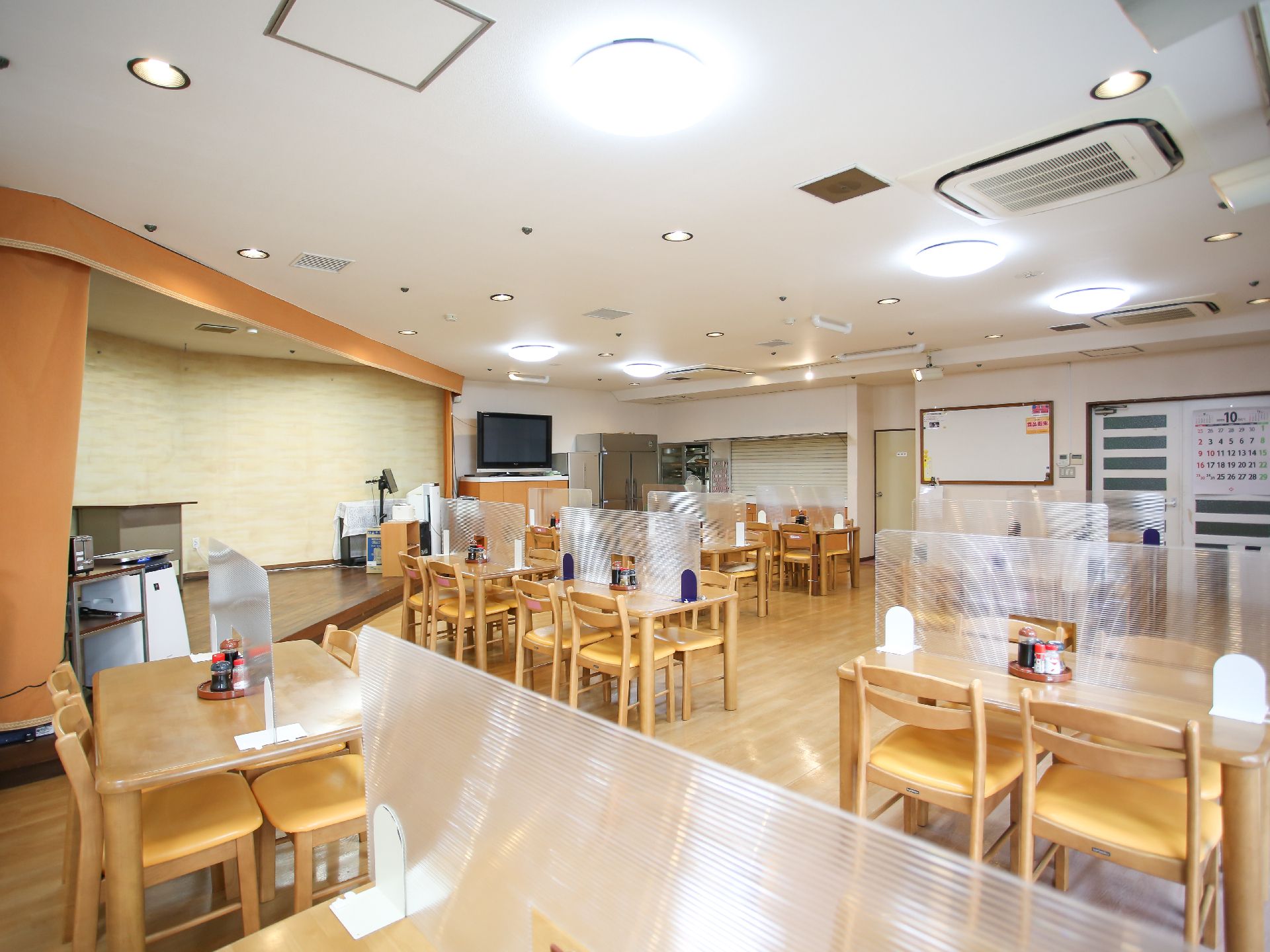 テーブルに飛沫対策用の仕切りがされている食堂兼集会室