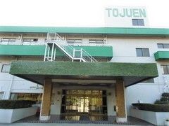 3階建ての建物は白とグリーン。「TOJUEN」と一番上の階の出っ張った部分に書かれている。