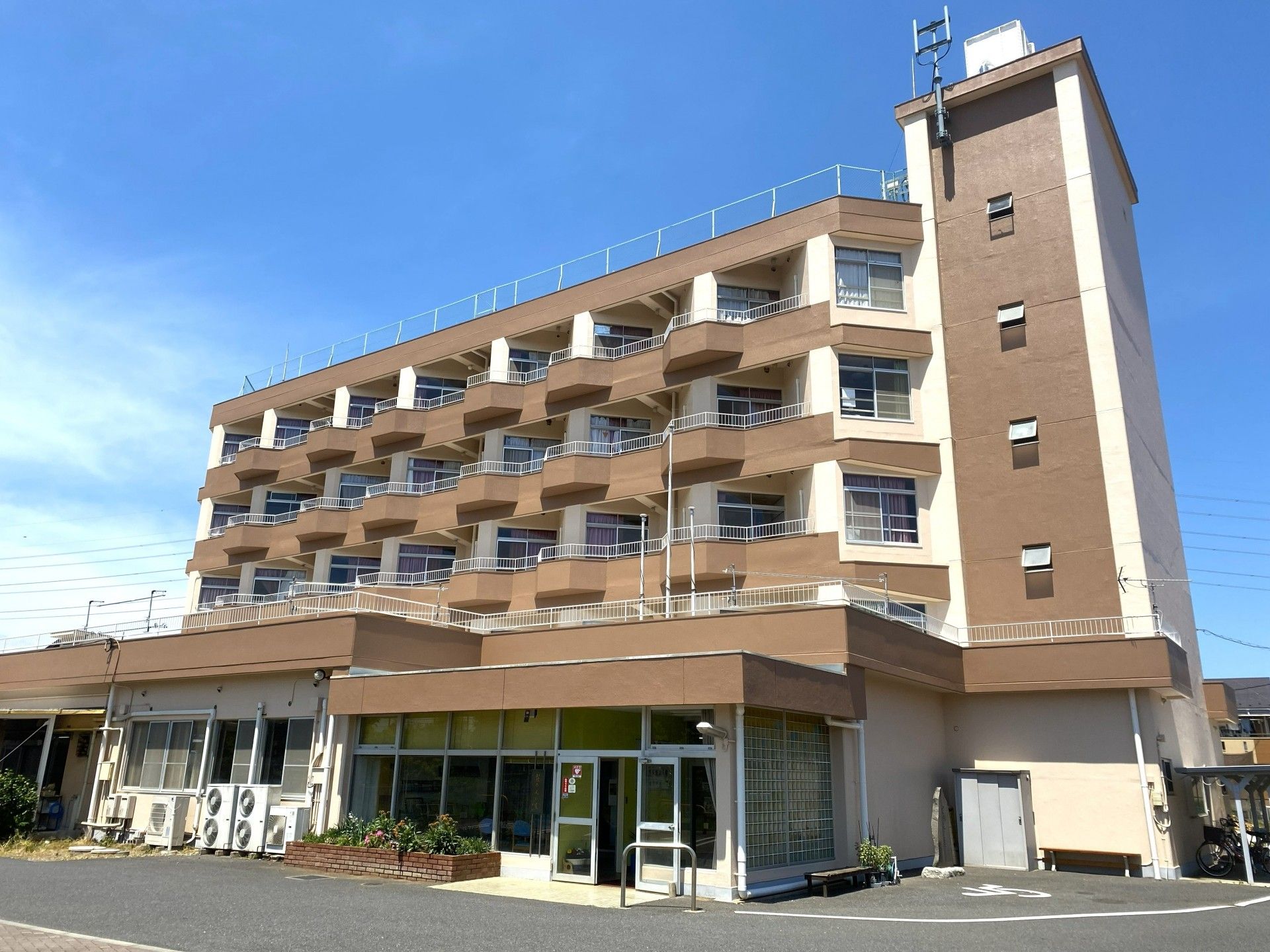 壁沿いにクッションが置かれた椅子が用意されているエレベーターホール