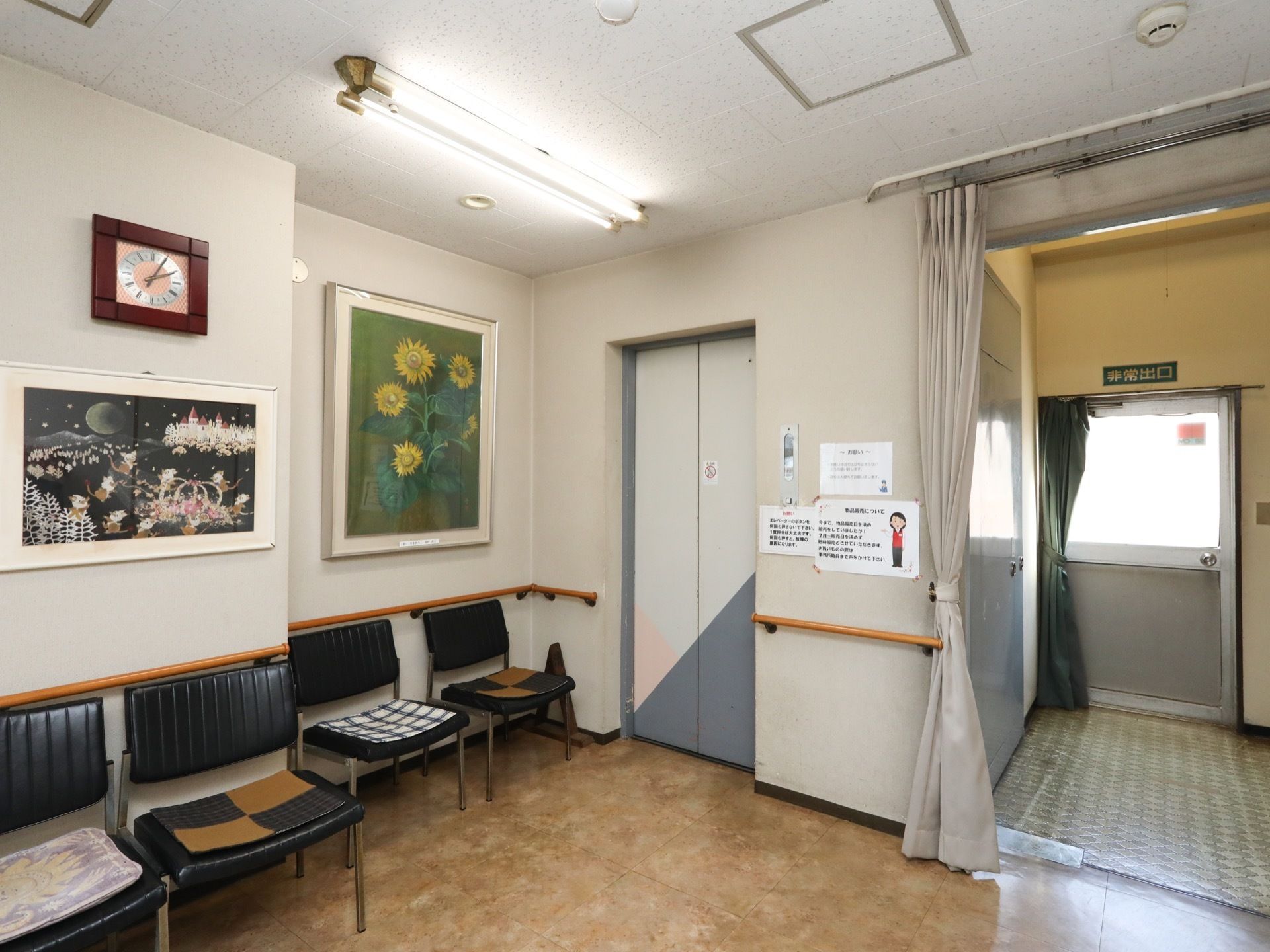 玄関ホールに乗降口の設置されているエレベーター。右には階段の入り口、そして外に出られる非常口ドアがある。