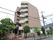 道路沿いに立地しているレンガ調の６階建ての建物