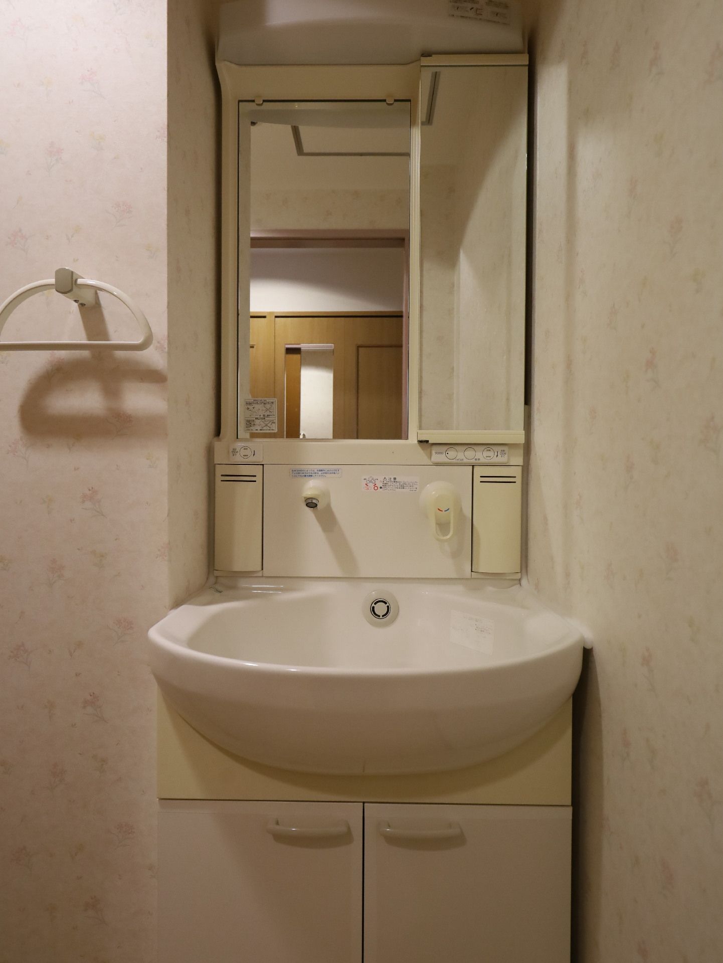 白い壁に埋め込まれている鏡のついた洗面台