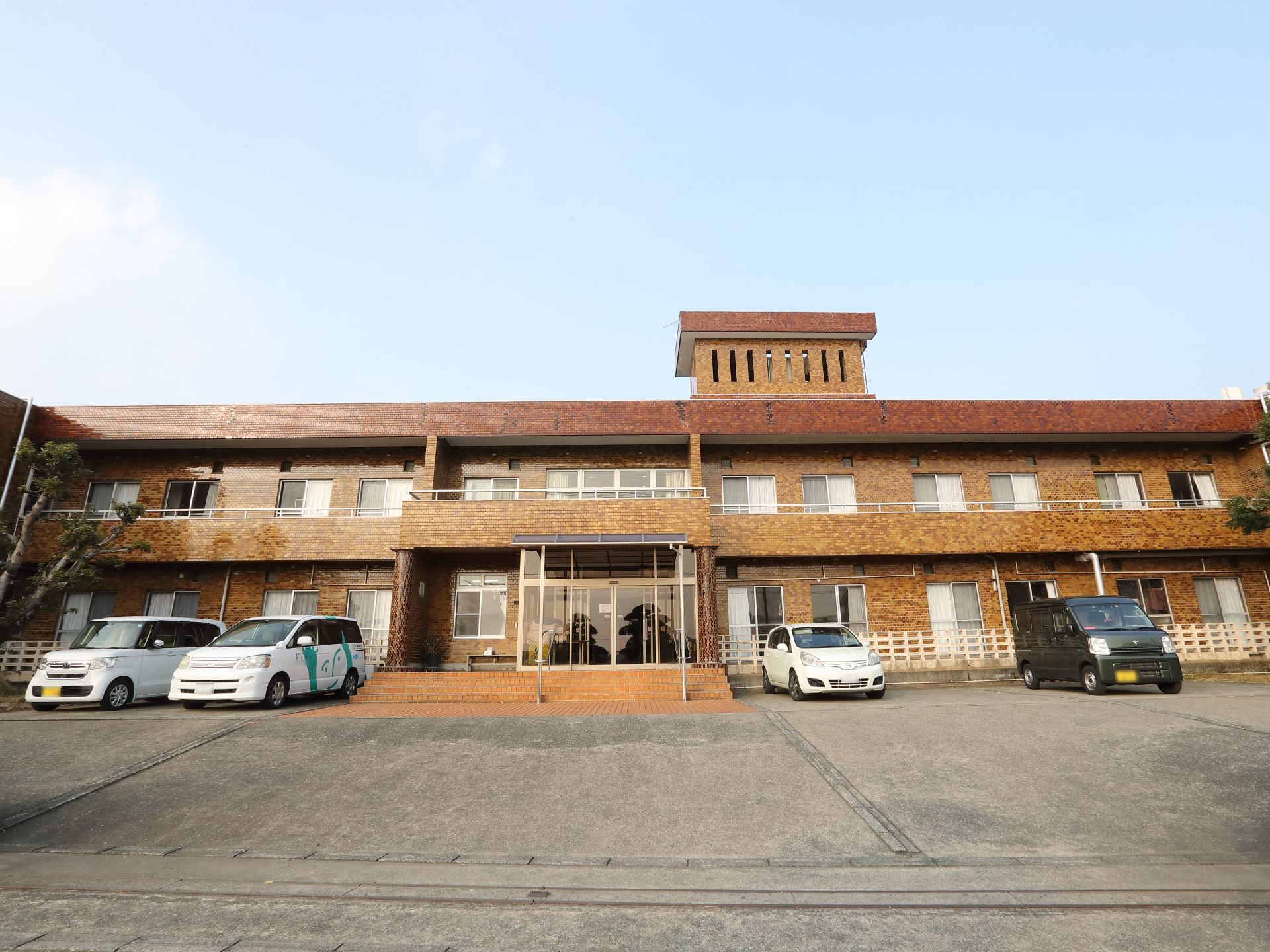 2階建てのケアハウスの建物と駐車場