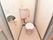 淡いピンクで統一された、落ち着きのあるトイレである。非常呼び出しブザー、洋式便座が完備されている。清潔感がある。
