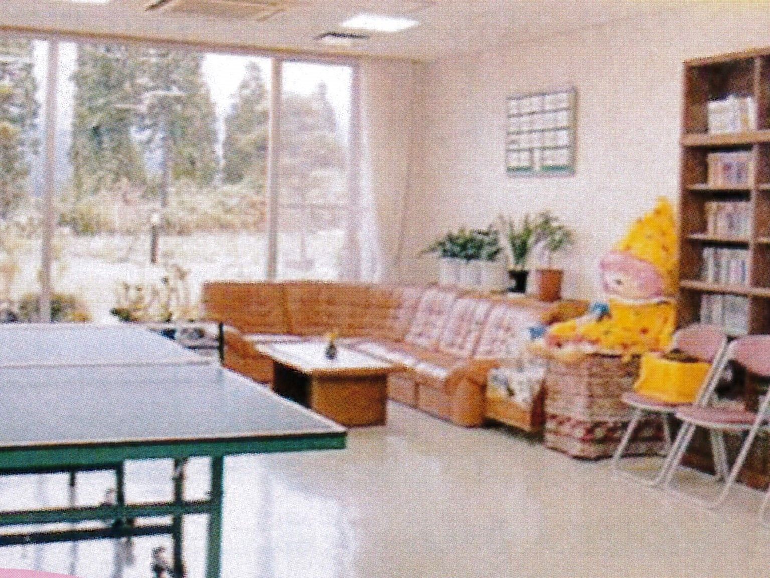 大きな窓が付き明るい雰囲気の交流室には、卓球台や本棚、ソファコーナーがある。