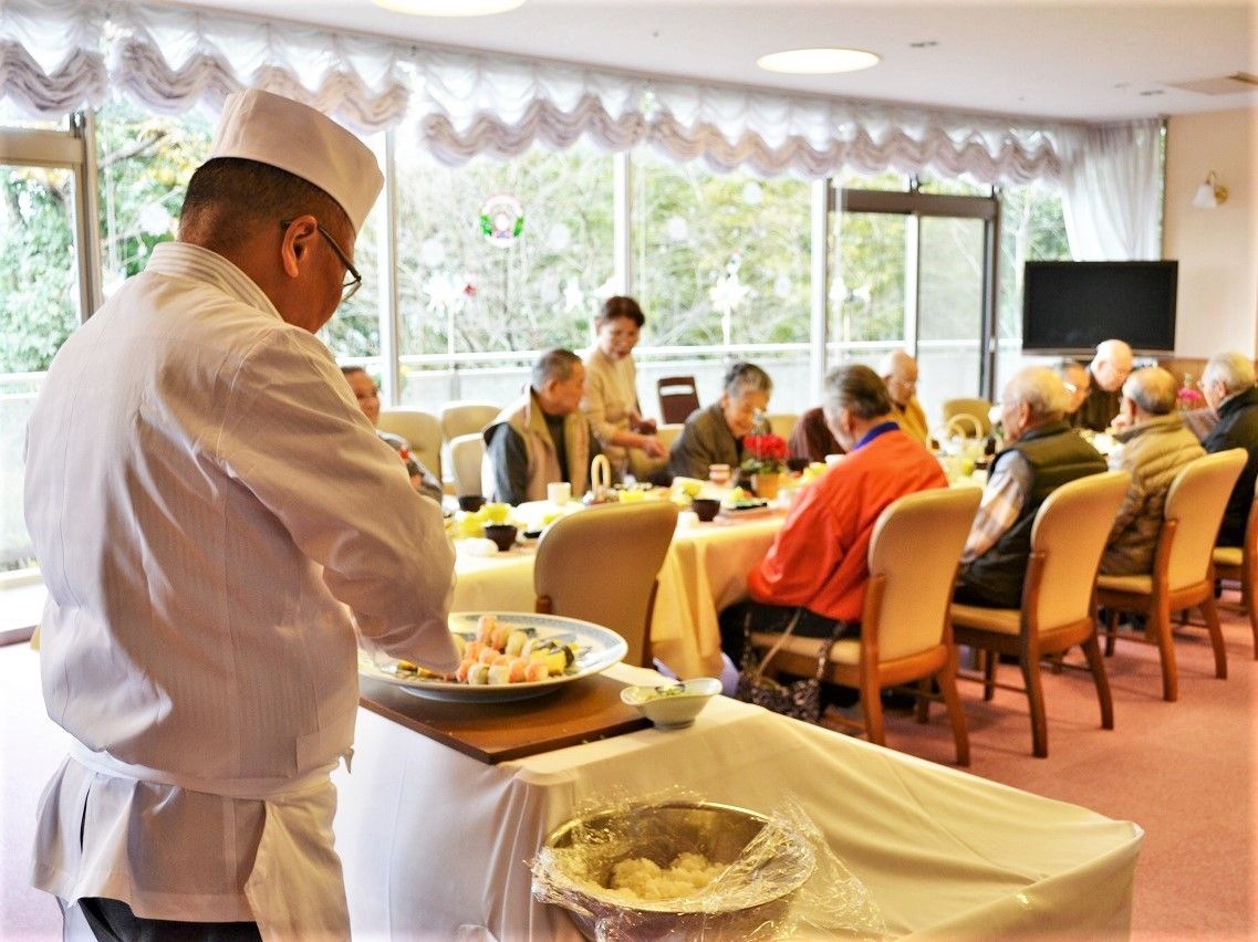 華やかな食卓風景。料理人が目の前で握り寿司を握っている様子。