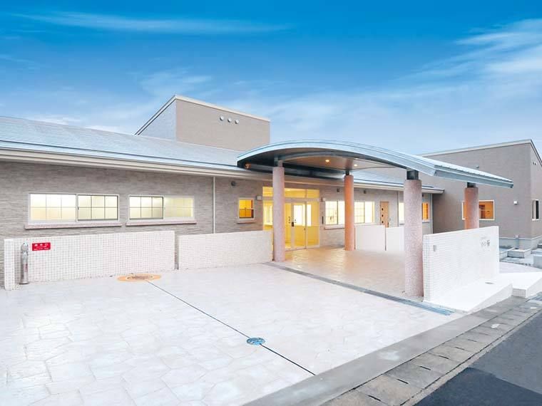 玄関には車寄せが付き、平屋建ての建物には明かりが灯っている。