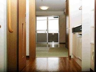 一人用の小さな部屋の写真。右側にキッチン、中央に窓がある施設内の居室スペース