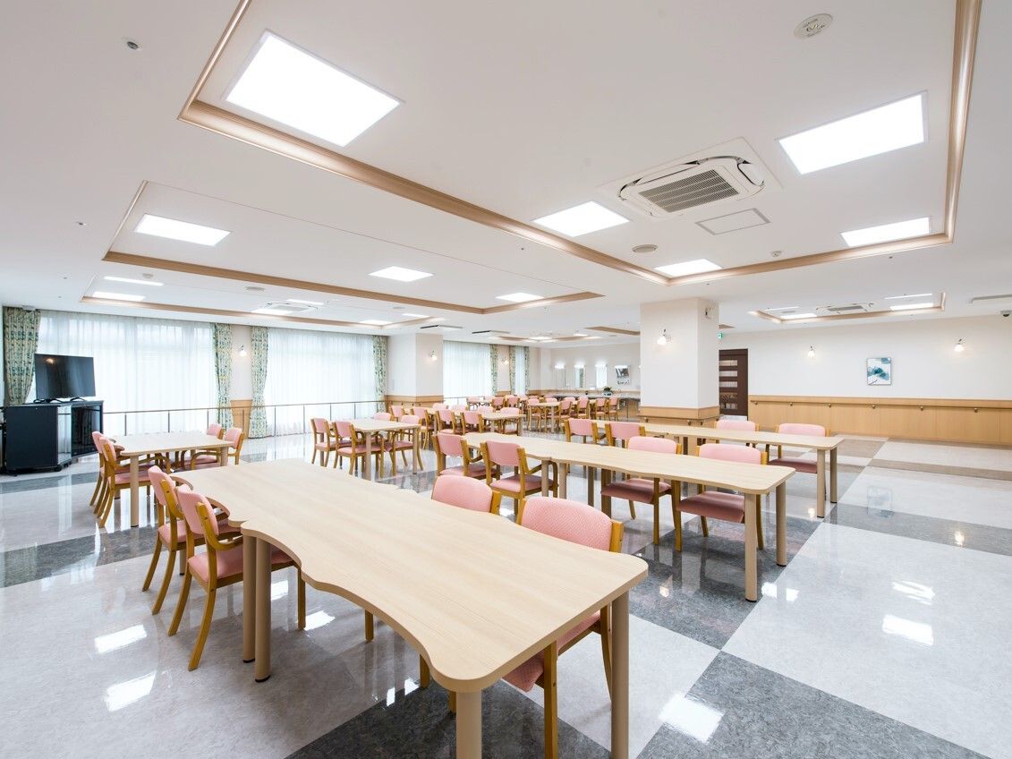 テレビが設置された食堂にはダイニングテーブルが複数あり、大きな窓が付いている。