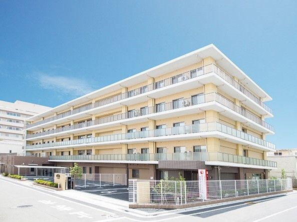 各フロアにベランダがあり、玄関には屋根が付いた5階建ての建物は日当たりのいい場所に建っている。