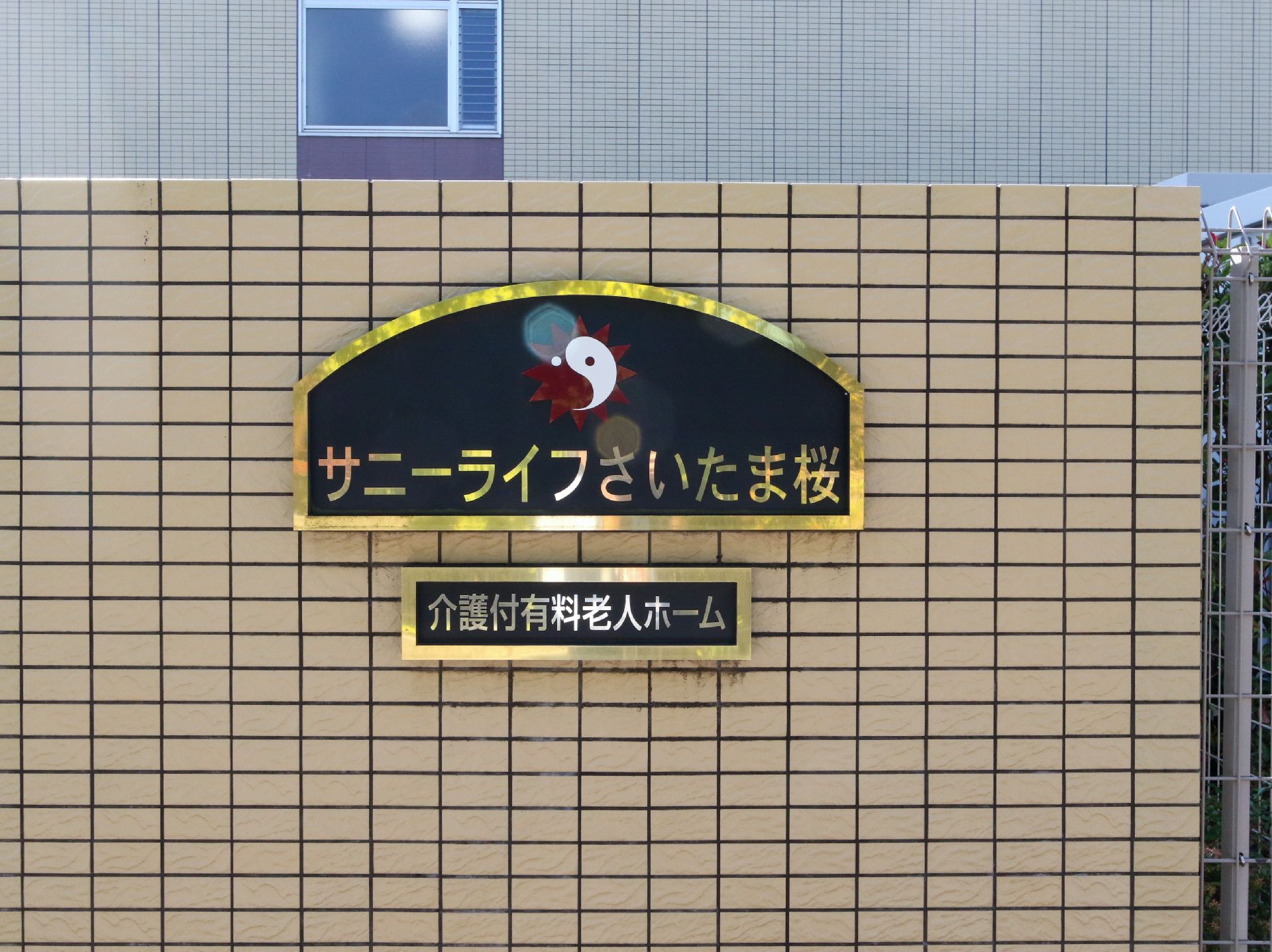 金色の縁と文字で施設名が書かれている看板