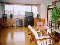 カラオケ機器が設置された部屋。木のテーブルやいす、観葉植物も置かれている。