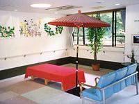 赤い傘の下に赤い布が敷かれたベンチを設置し、お茶屋さんのような和の雰囲気がある。