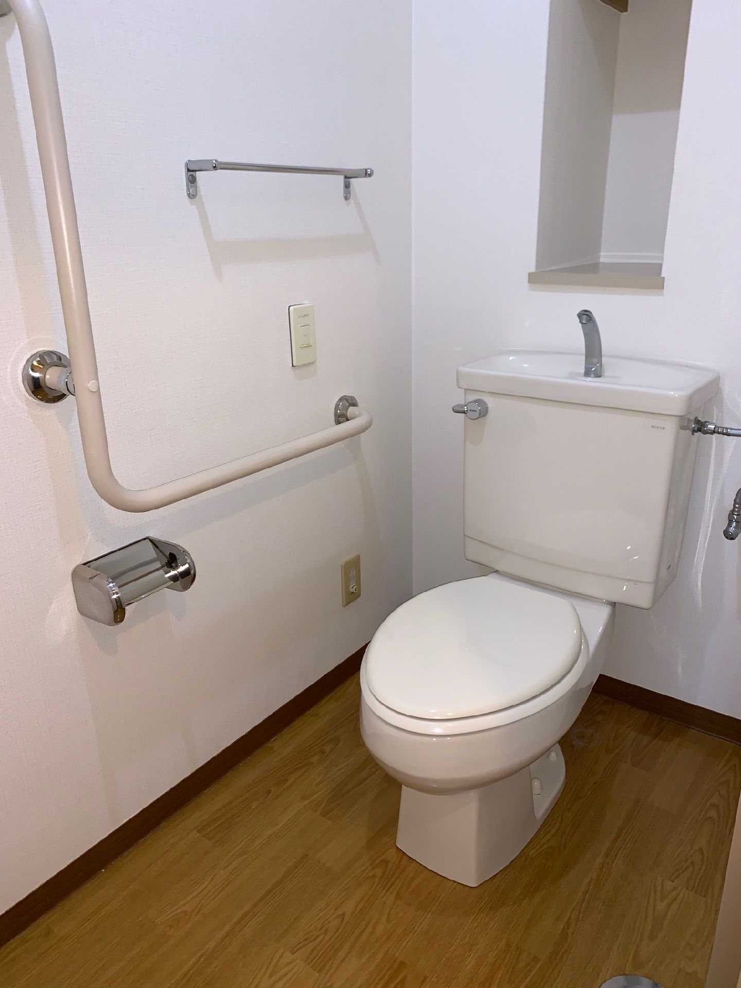 トイレはフローリングできれいに掃除がされていて、手すりが設置されている。