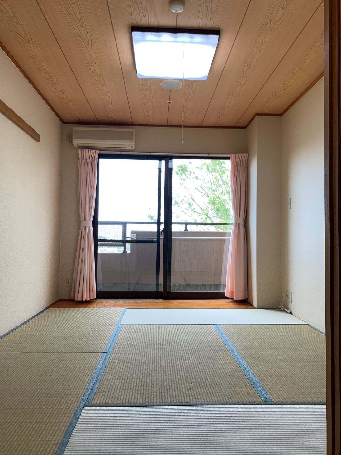 畳敷きの居室。窓が大きく、白い壁が部屋を余計広く見せている。