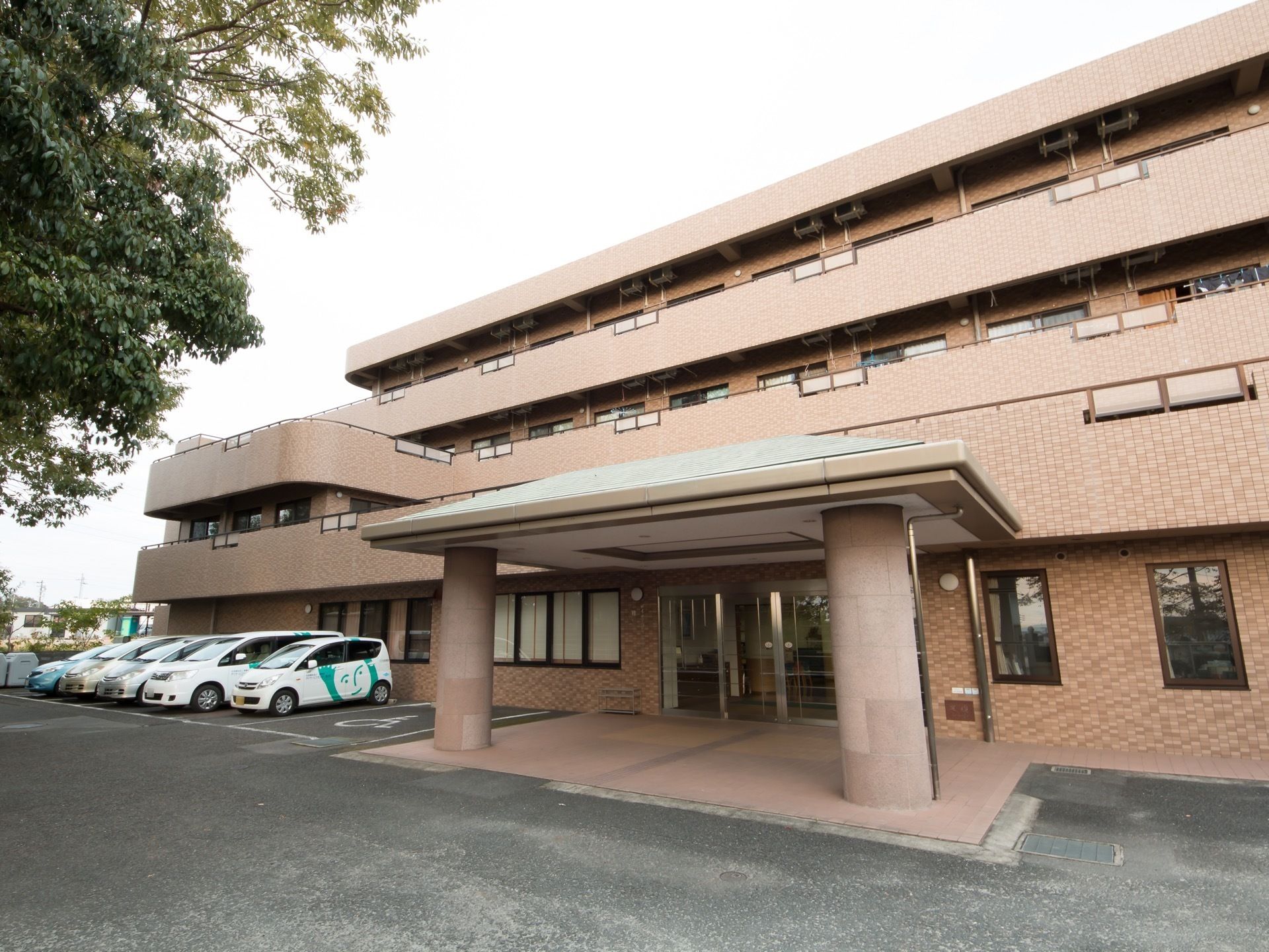 マンション風の建物になっている。敷地内には駐車場が用意されており、車が何台か停まっている。入口は自動扉になっている。