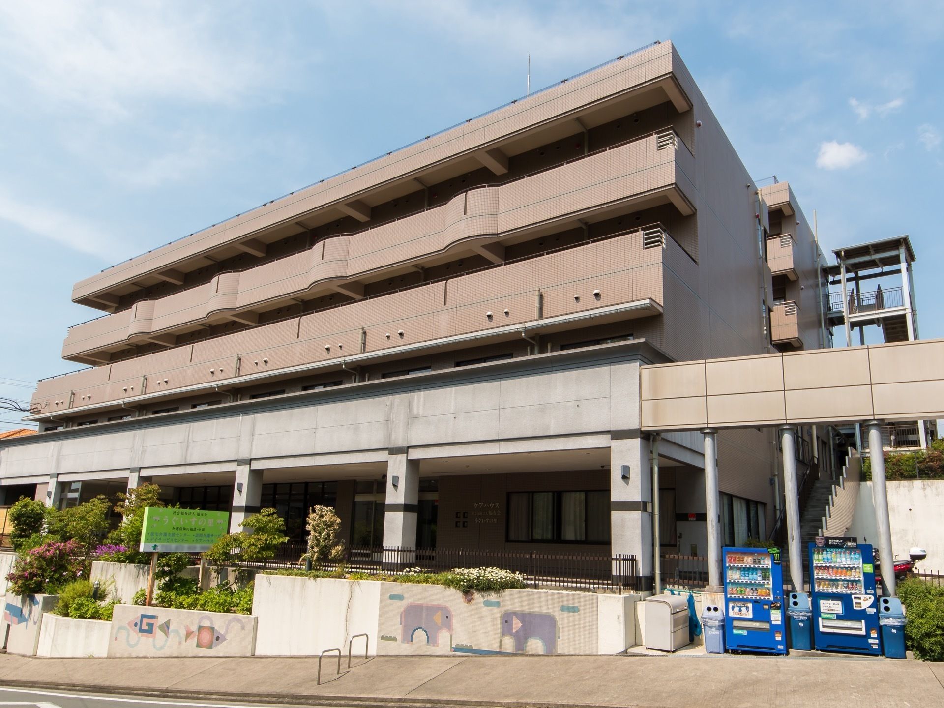 施設はマンション風の４階建ての建物である。外階段が設けられており、建物前に２台の自販機が設置されている。