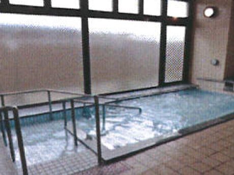 プールのような大きさの浴槽の様子。広めの空間がある共同浴室の写真