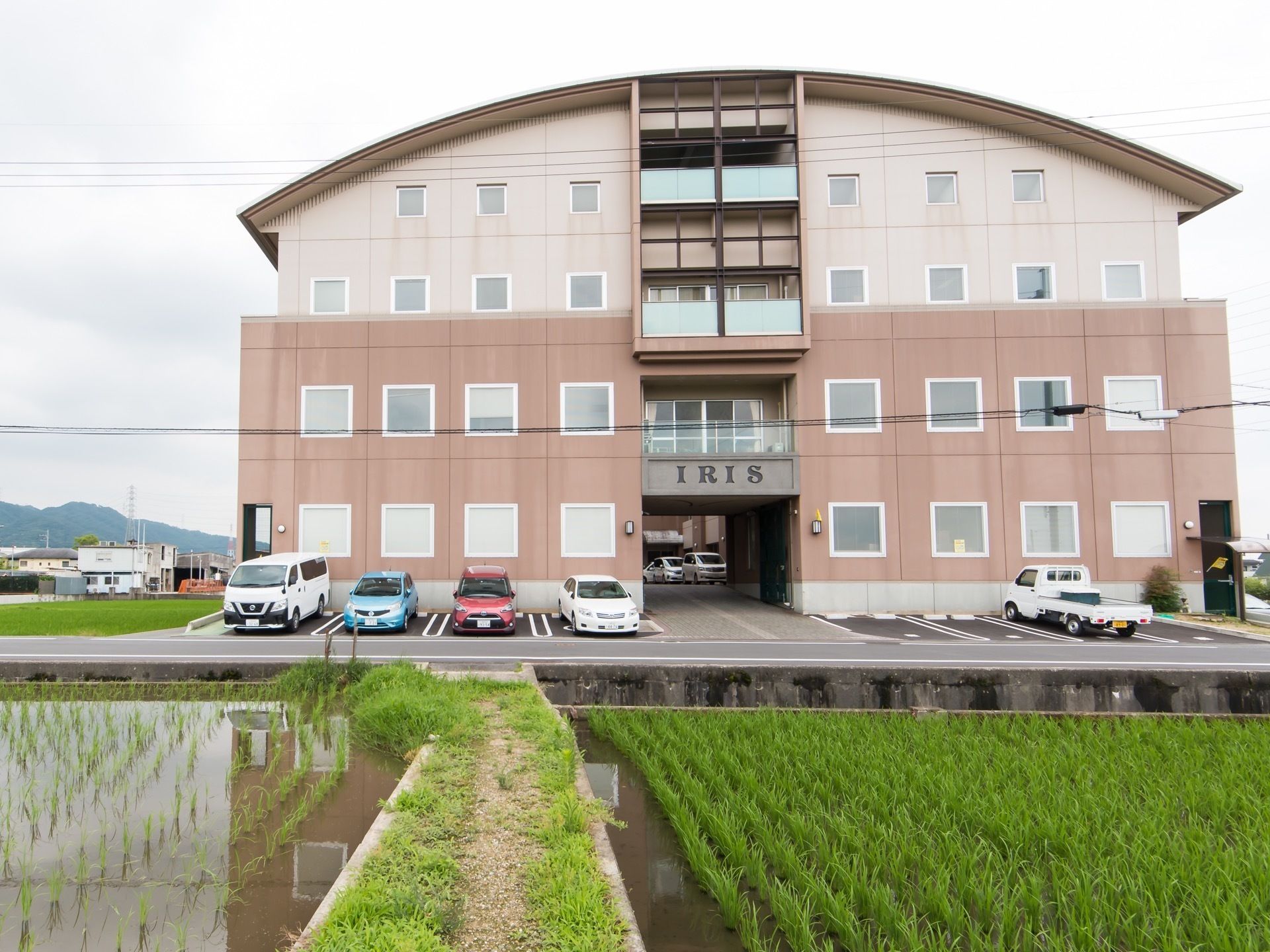 ４階建てのモダンな建物である。周辺は自然に恵まれたのどかな立地で、目の前には田んぼがある。交通量が少なく静かである。