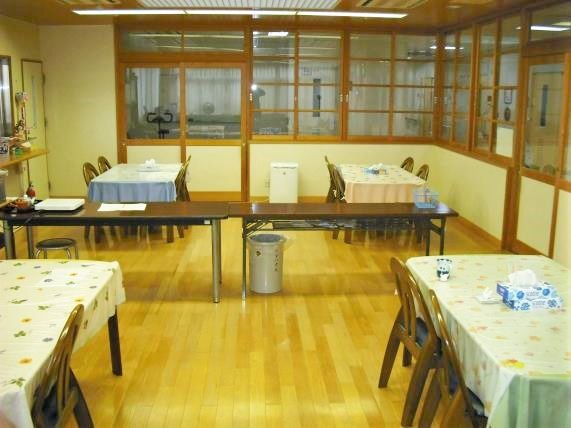 がらの異なるテーブルクロスがかけられたダイニングテーブルが並ぶ食堂。