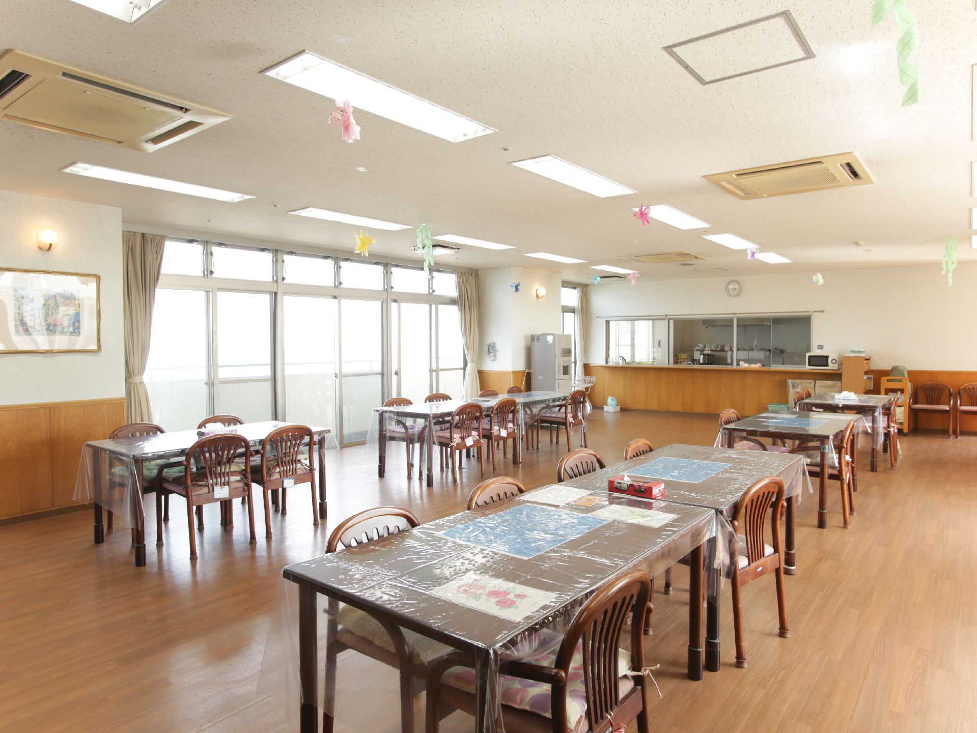 茶色のテーブルと椅子が三つ並んだ食堂