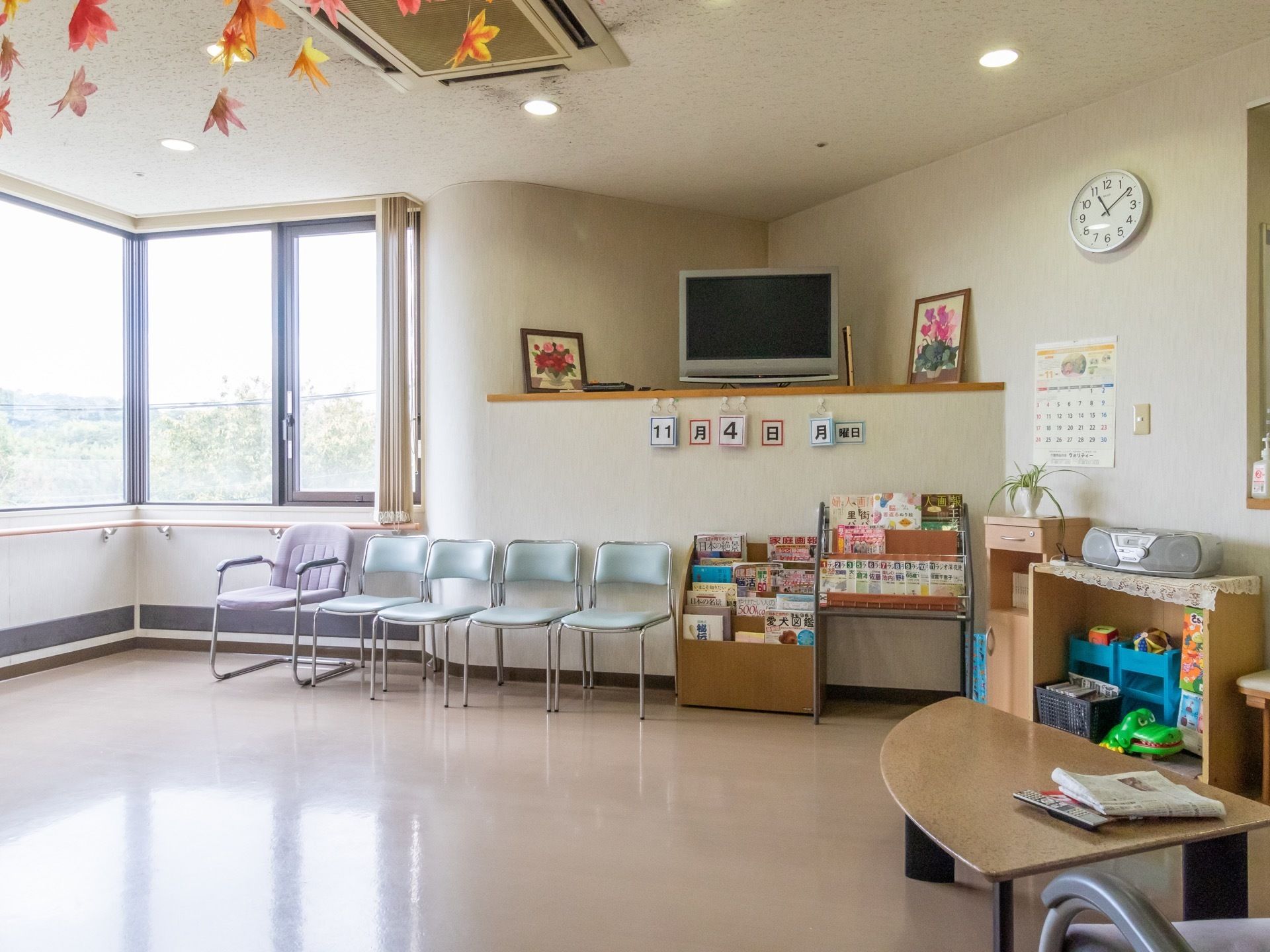 テレビや雑誌、ラジカセやおもちゃが用意されている明るいリビング。棚の上には、テレビや絵が置かれている。