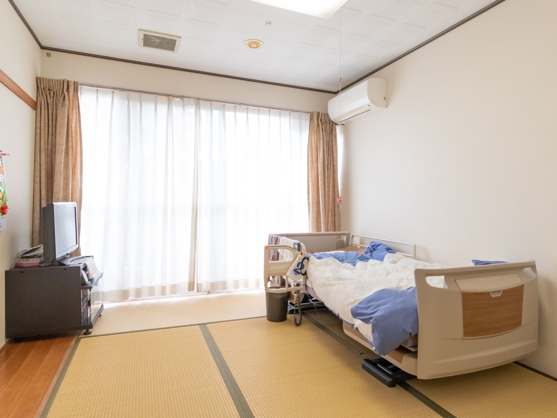 テレビやテーブルセットが配置されたエアコン付きの居室