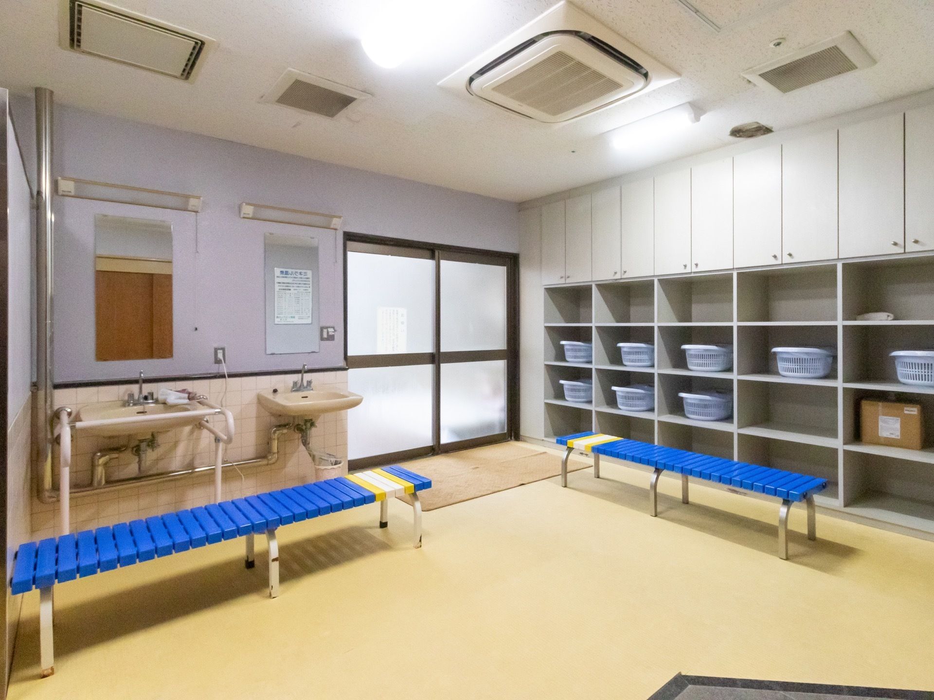 脱衣所は広いスペースで、壁際には棚が設置されている。棚には大きなかごが置いてあり、着替えなどを入れることができる。