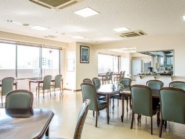 大きな窓が付いた食堂にはダイニングテーブルが複数置かれたスペースと窓際のカウンター席があり、いずれにも複数名の入居者がいる。